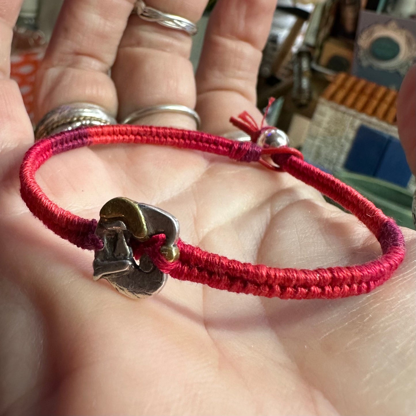An adorable handmade fine silver Santa with gold trim on a vivid red leather, cotton and sterling silver woven friendship bracelet…