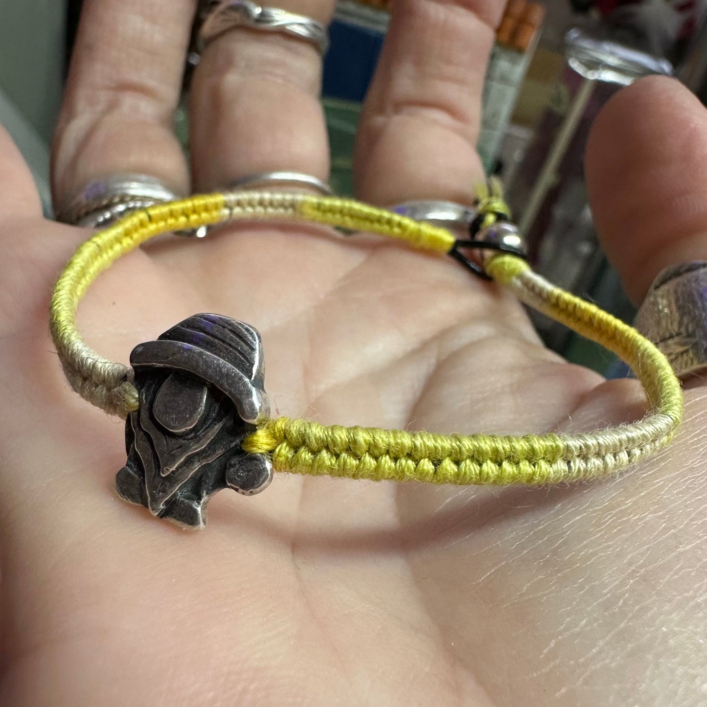 A handmade fine silver Norm nisse gnome on a lovely yellow leather and cotton friendship bracelet, finished with a sterling silver bead.