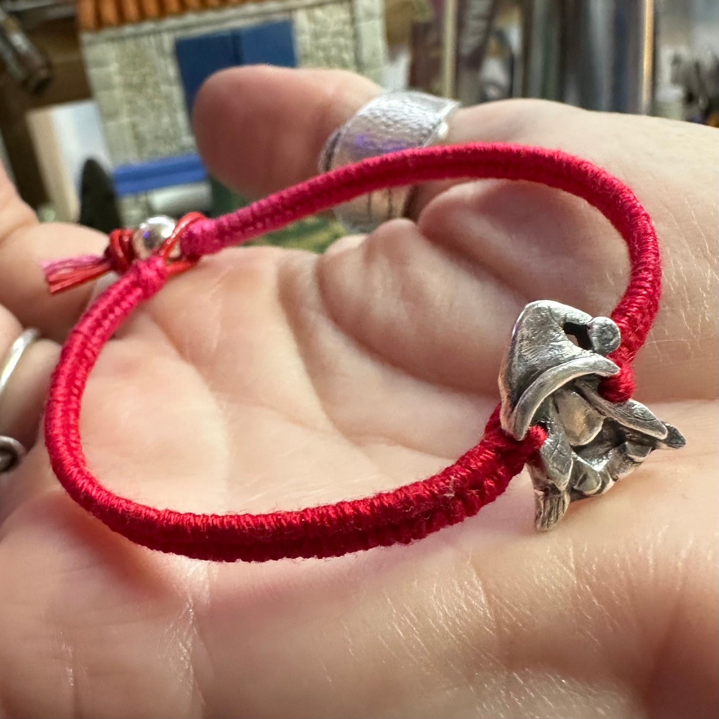 A handmade fine silver Norma nisse lady gnome on a fab red leather and cotton friendship bracelet, finished with a sterling silver bead.