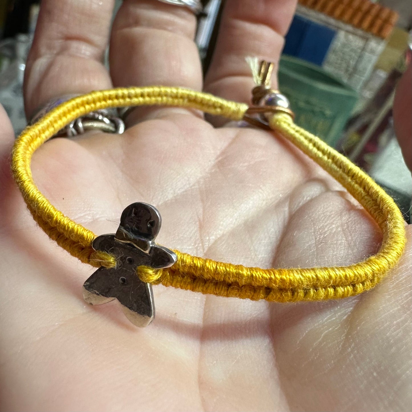 A handmade fine silver gingerbread man with a gold bow tie on a lovely yellow leather, cotton and sterling silver woven friendship bracelet…