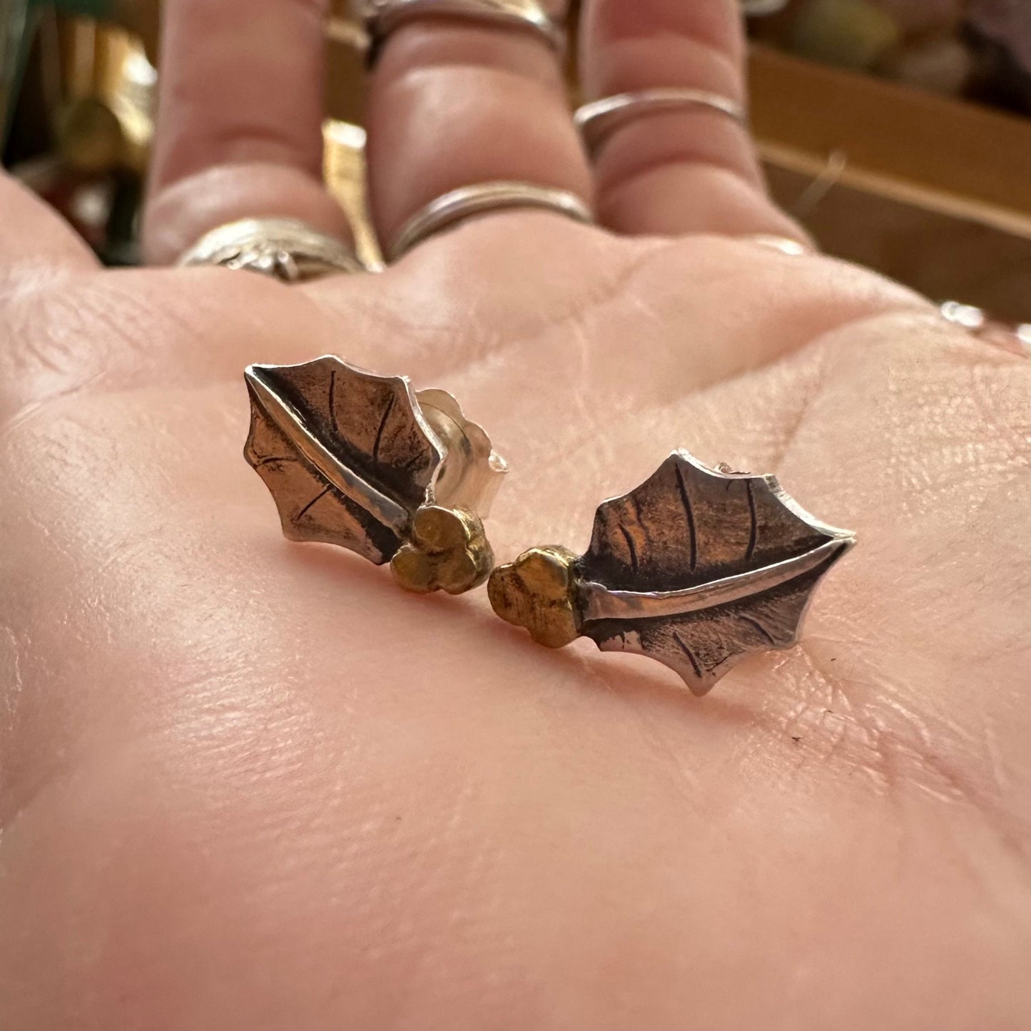 An adorable pair of fine silver holly leaf earrings with gold berries on sterling silver stud wires.