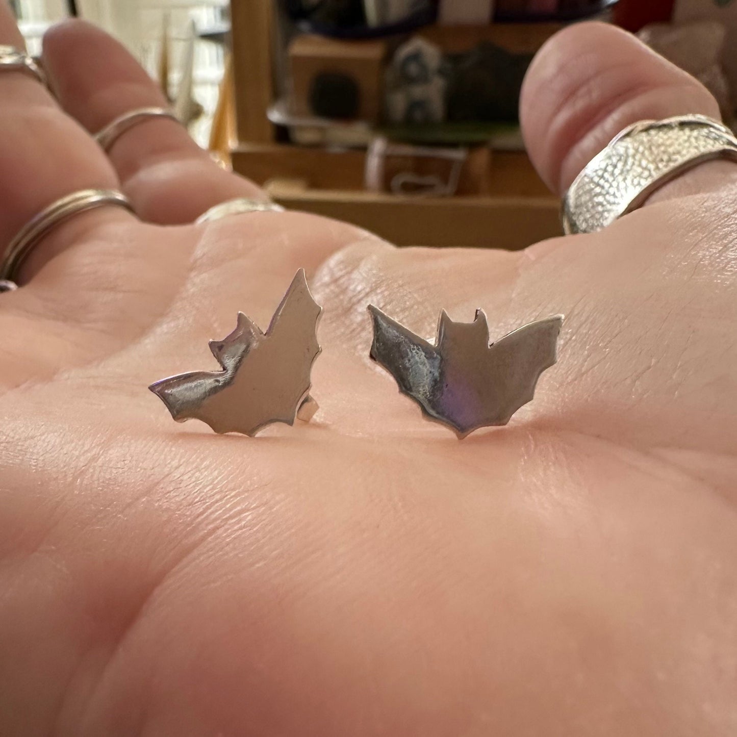 A pair of little fine silver bat stud earrings on sterling silver posts.