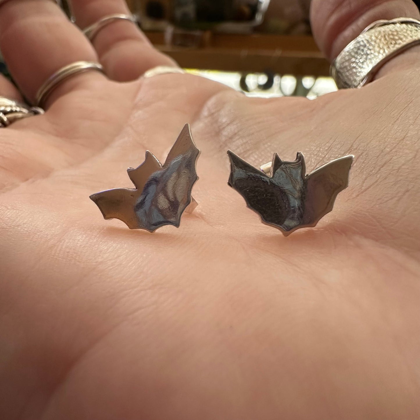A pair of little fine silver bat stud earrings on sterling silver posts.