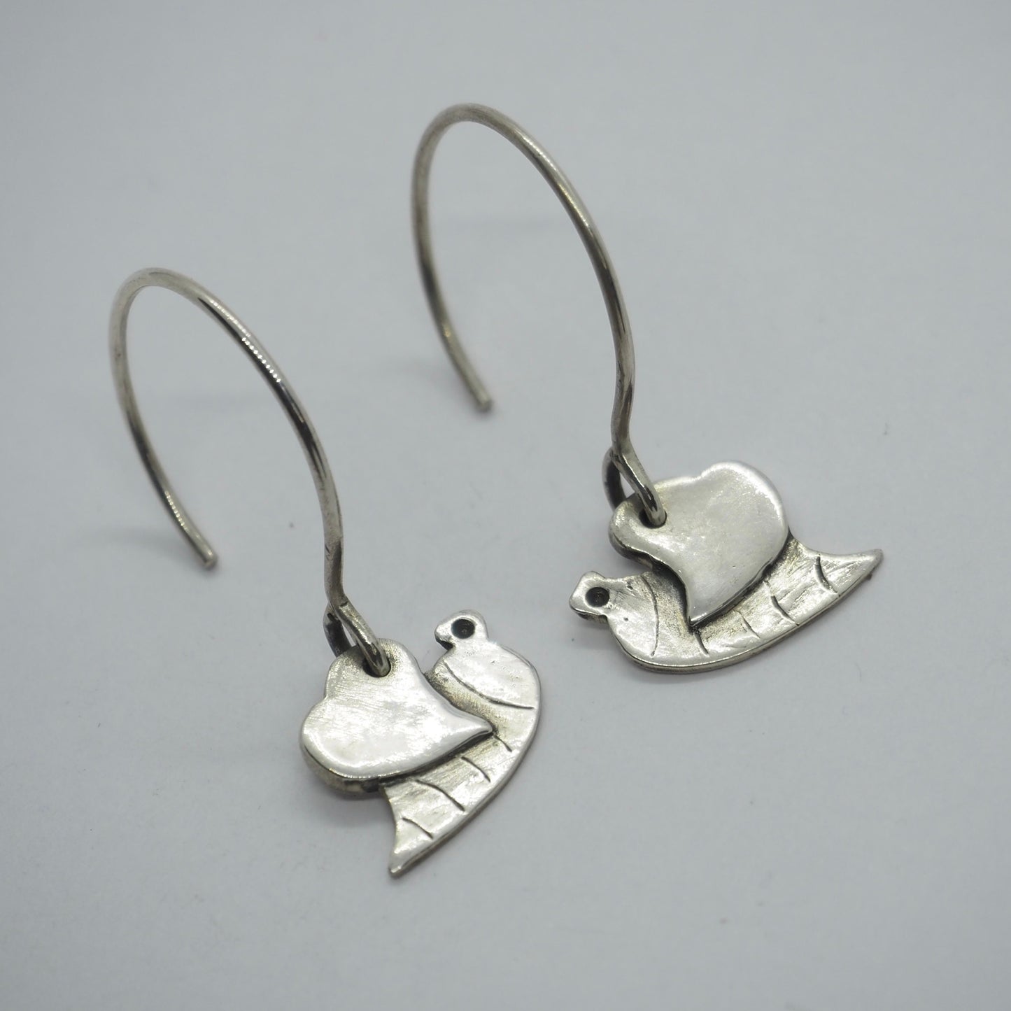 A lovely little pair of handmade fine silver cartoon bee earrings on hand formed sterling silver wires.