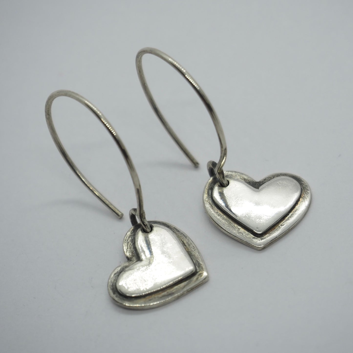 A pair of lovely simple heart earrings handmade in fine silver on handmade sterling silver wires.