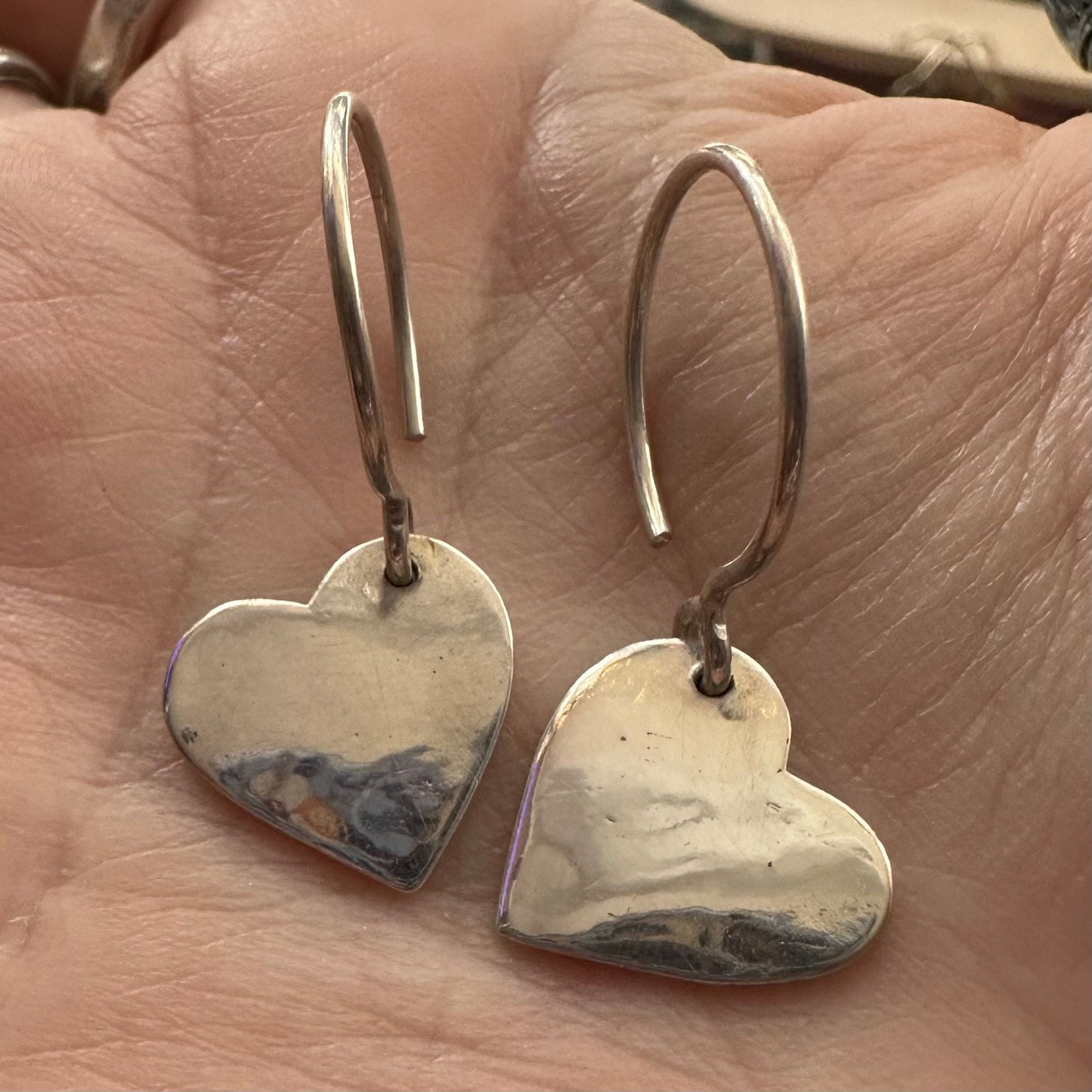 A pair of delightfully simple fine silver heart earrings on handmade sterling silver wires.