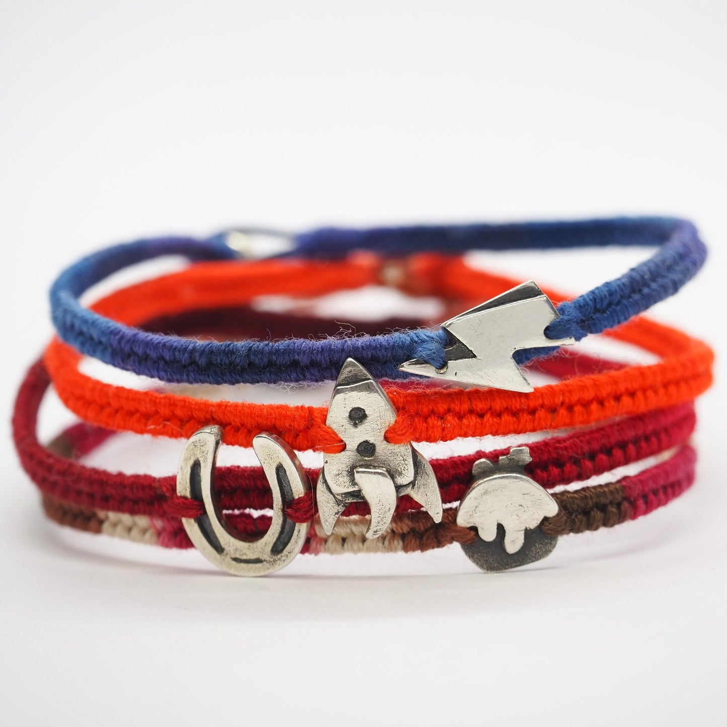 A cute unique tiny fine silver rocket on a beautiful orange leather, sterling silver and cotton woven charm bracelet.
