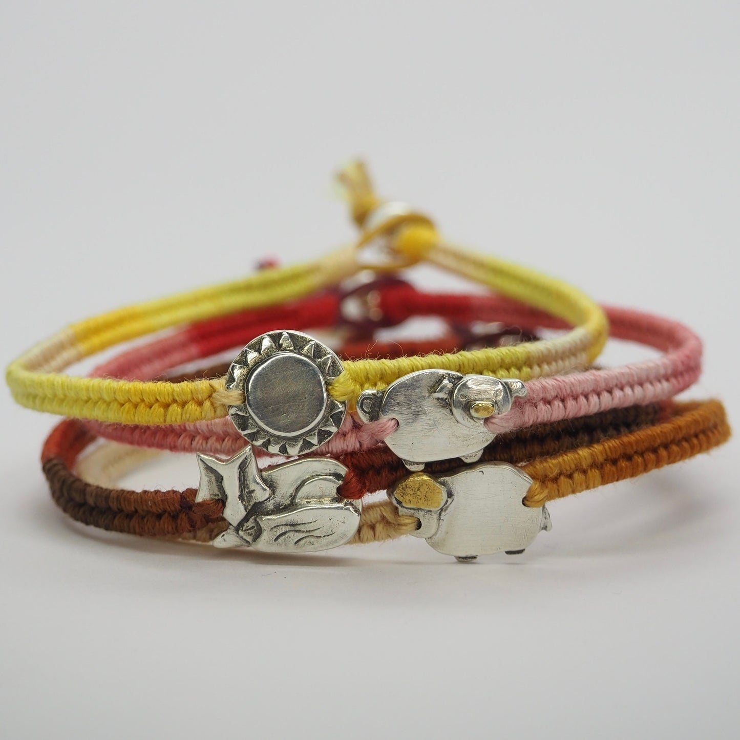 An adorable little sheep handmade in fine silver and gold on a yellows and orange leather, cotton and sterling silver friendship bracelet.