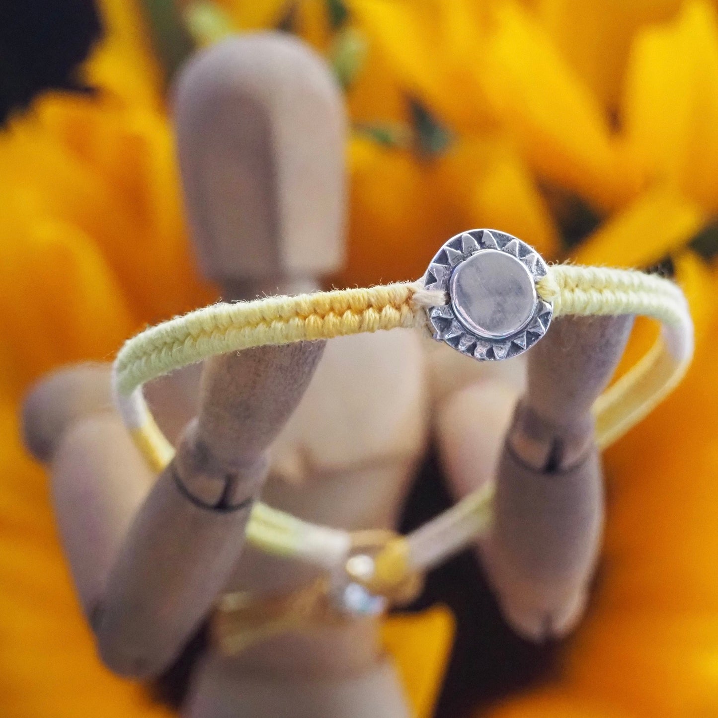 A beaming sun handmade in fine silver on a gorgeous yellow, orange, friendship bracelet in leather, cotton and sterling silver.