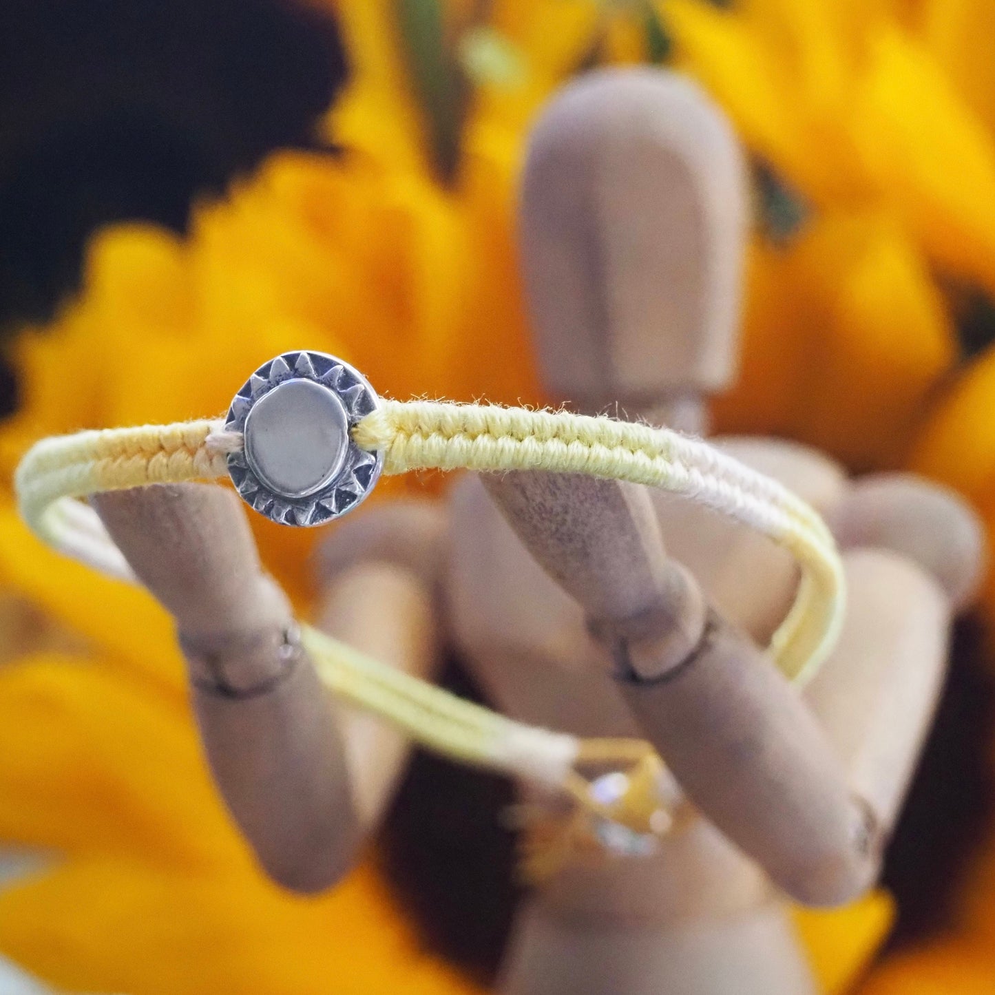 A beaming sun handmade in fine silver on a gorgeous yellow, orange, friendship bracelet in leather, cotton and sterling silver.