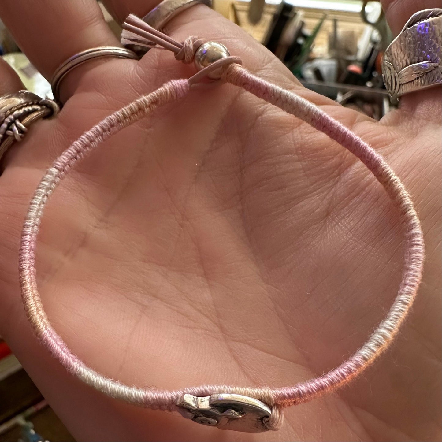 A tiny hand made fine silver piggie on a pretty pinks leather, sterling silver and cotton friendship bracelet.