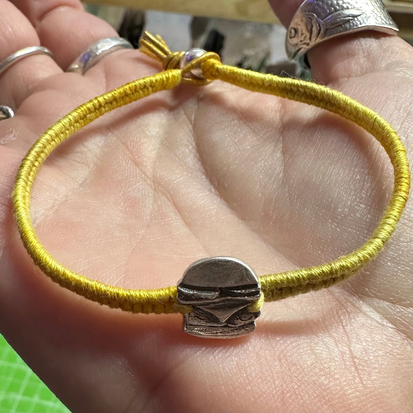 A unique tiny fine silver burger charm on a beautiful yellow leather, sterling silver and cotton friendship bracelet.
