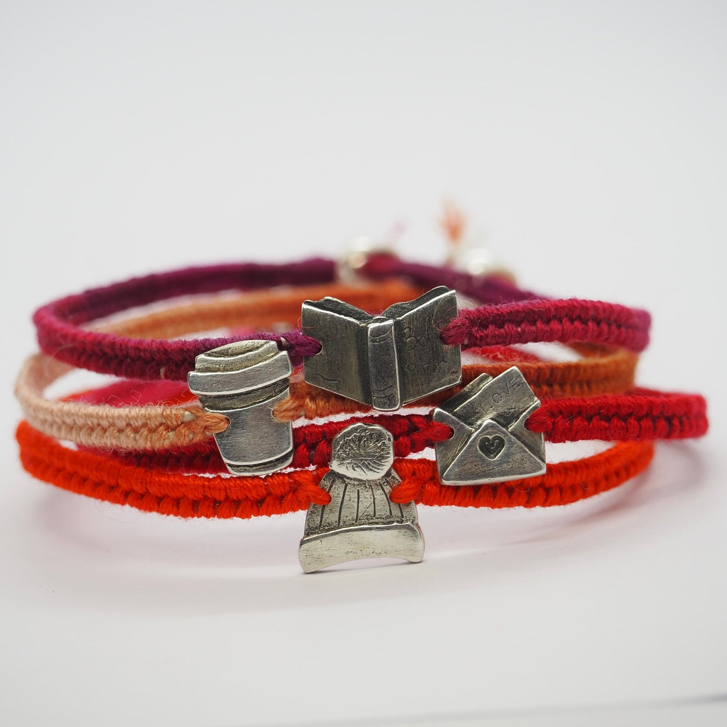 A lovely fine silver love letter hand made in fine silver on a beautiful red leather and cotton friendship bracelet.