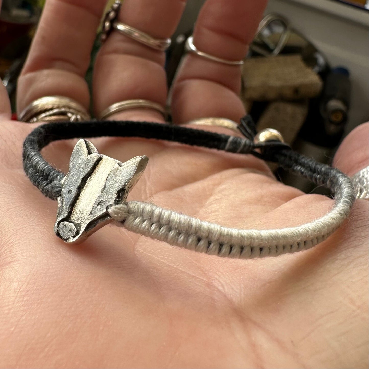 A lovely handmade fine silver badger on a soft black and grey leather, cotton friendship and sterling silver bracelet…