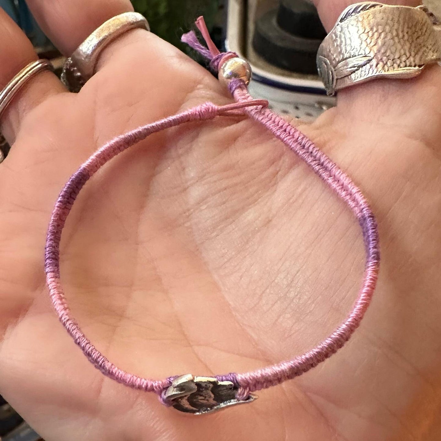 A gorgeous little fine silver angel wing on a beautiful pinky purple leather, cotton and sterling silver friendship bracelet.
