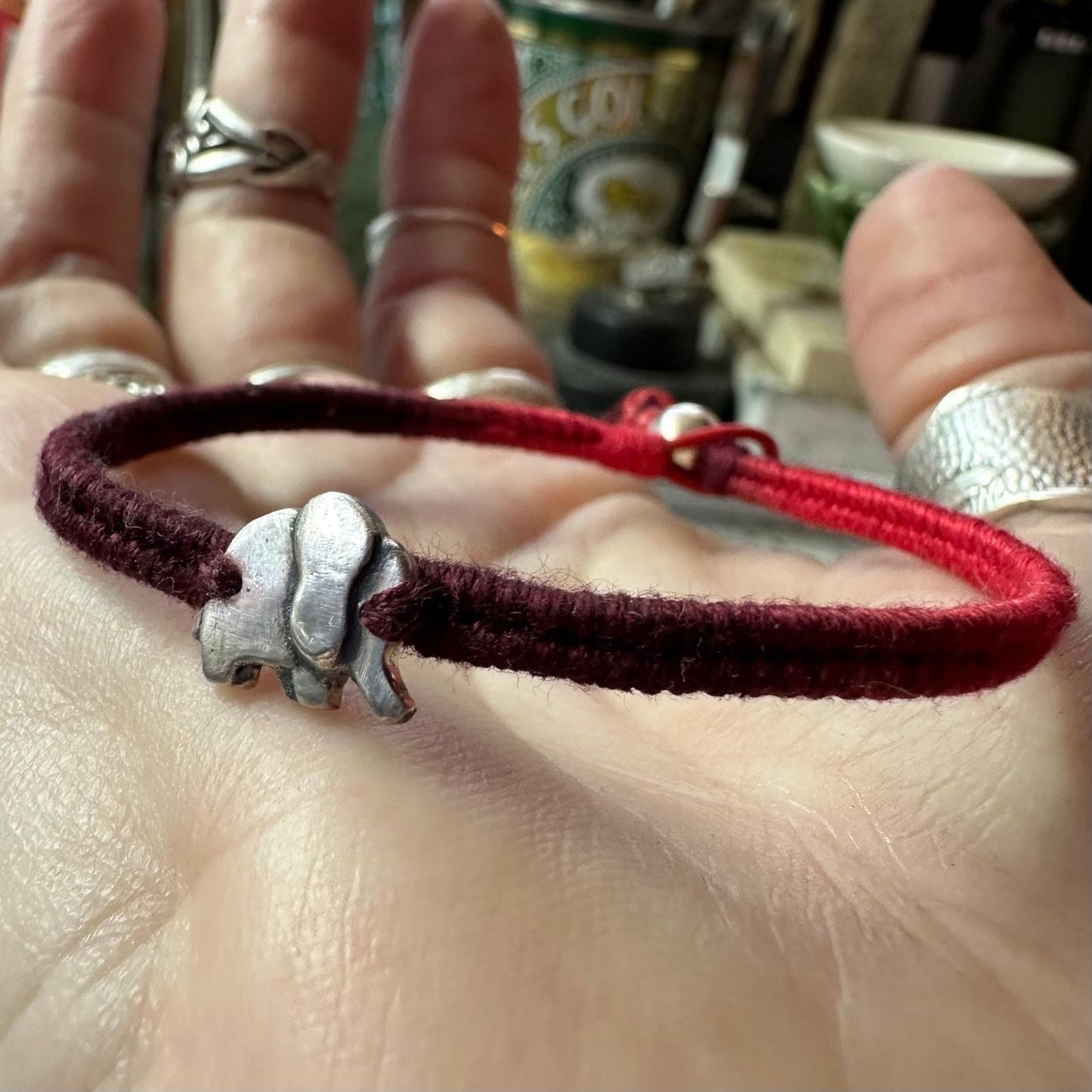 A lovely tiny unique handmade fine silver elephant a gorgeous deep red leather, cotton and sterling silver woven charm bracelet.