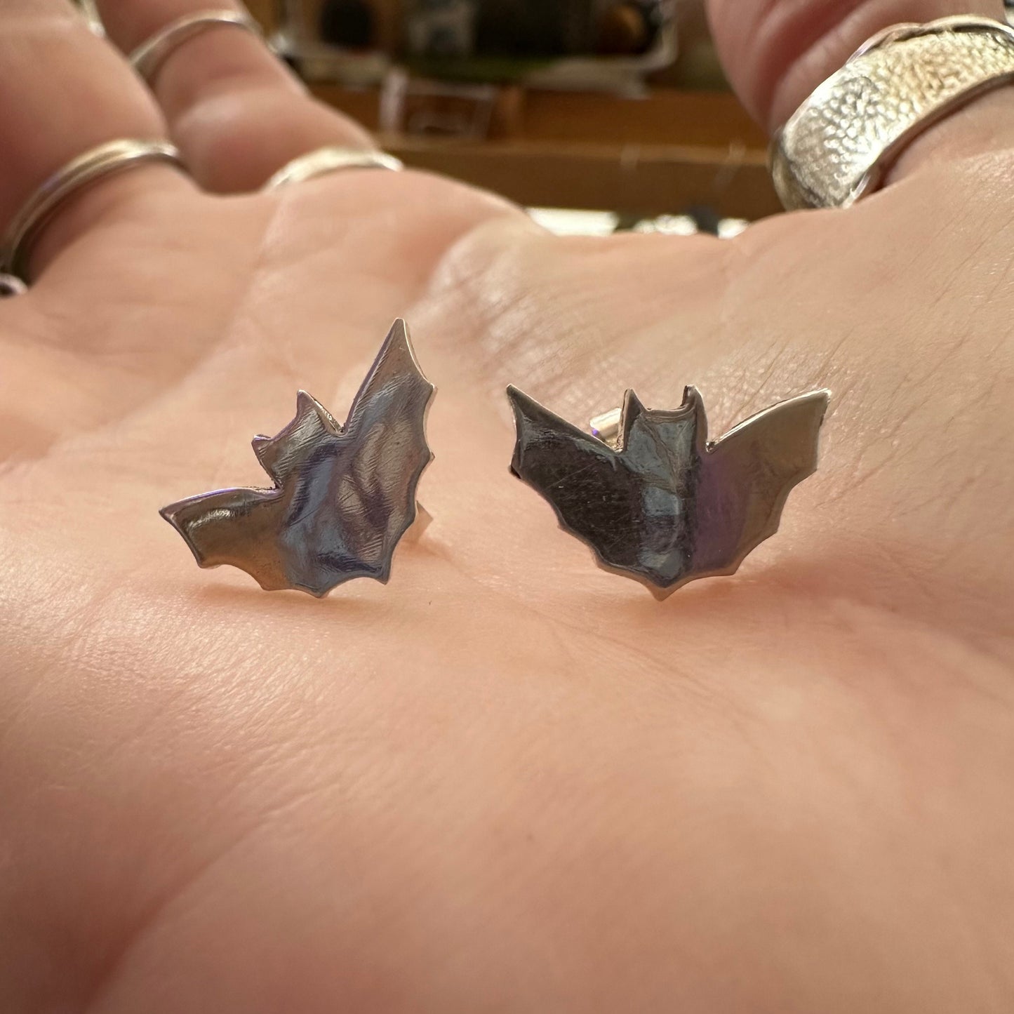 A pair of little fine silver bat stud earrings on sterling silver posts.