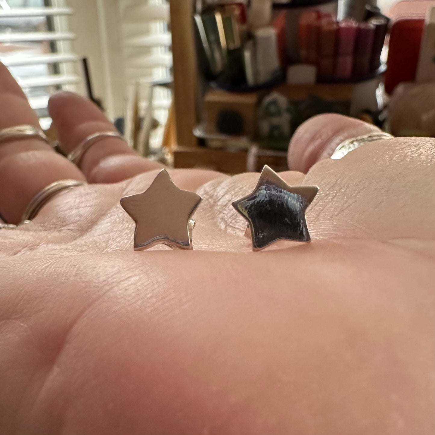 A pair of dainty fine silver star stud earrings on sterling silver posts.