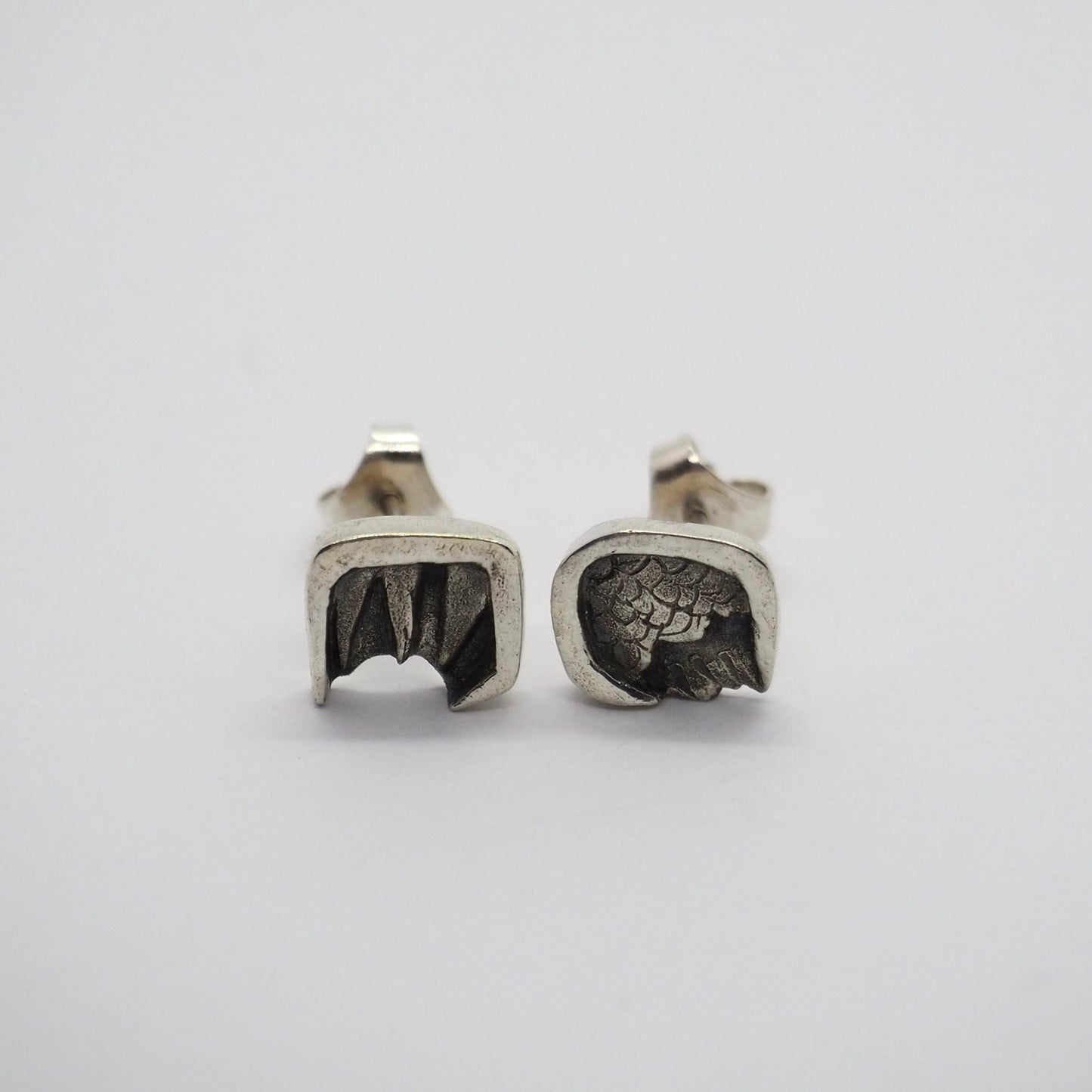 A gorgeous pair of eco friendly fine silver angel and devil wing stud earrings on sterling silver posts.