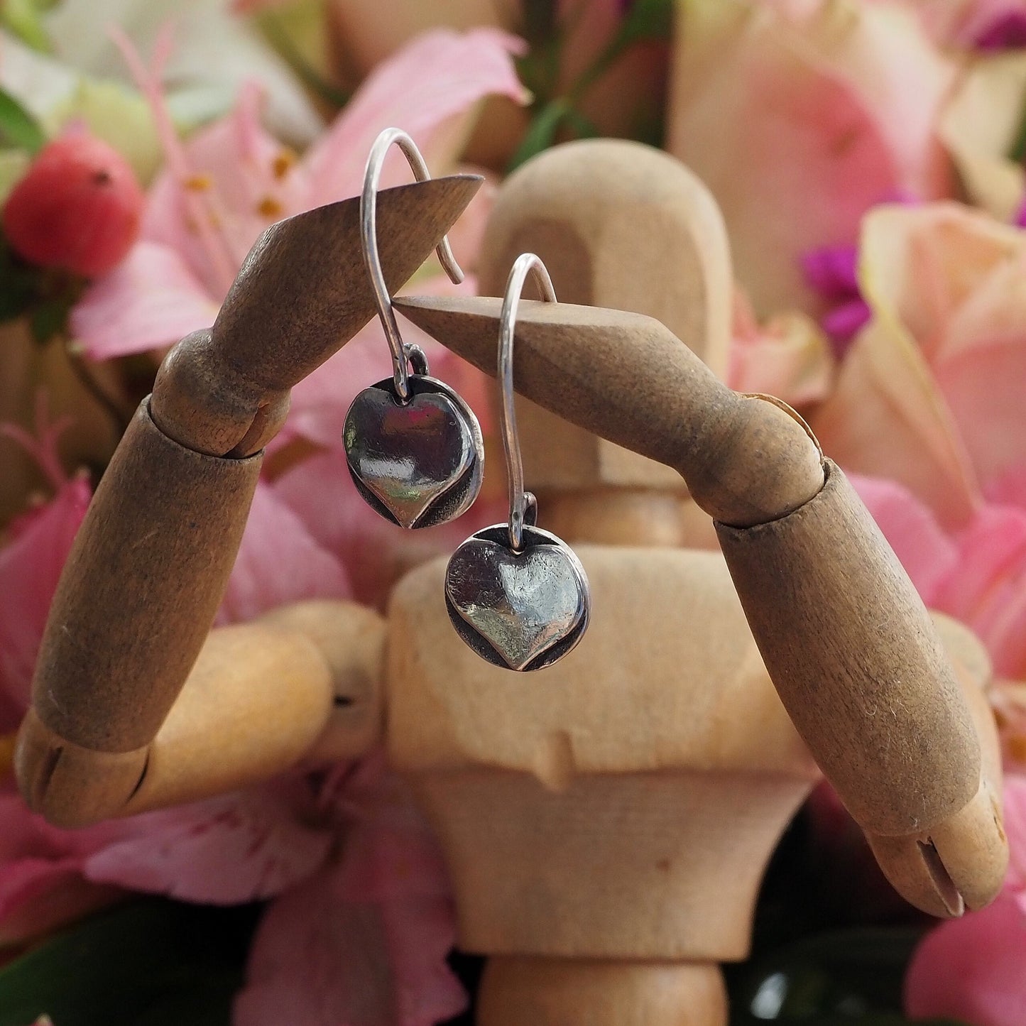 A pair of little simple heart earrings handmade in fine silver on handmade sterling silver wires.