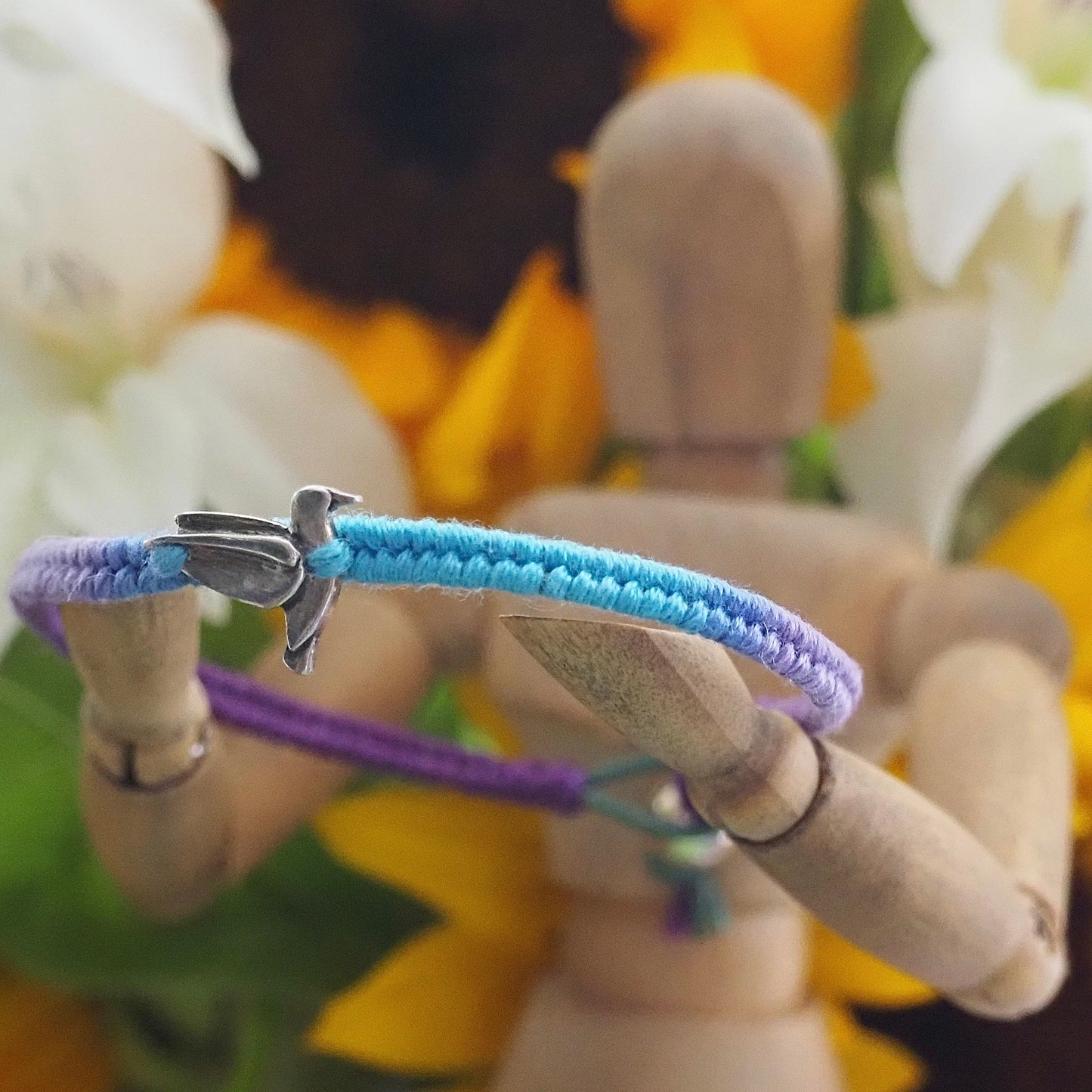 A lovely fine silver humming bird on a cute purple and turquoise leather, sterling silver and cotton friendship bracelet.