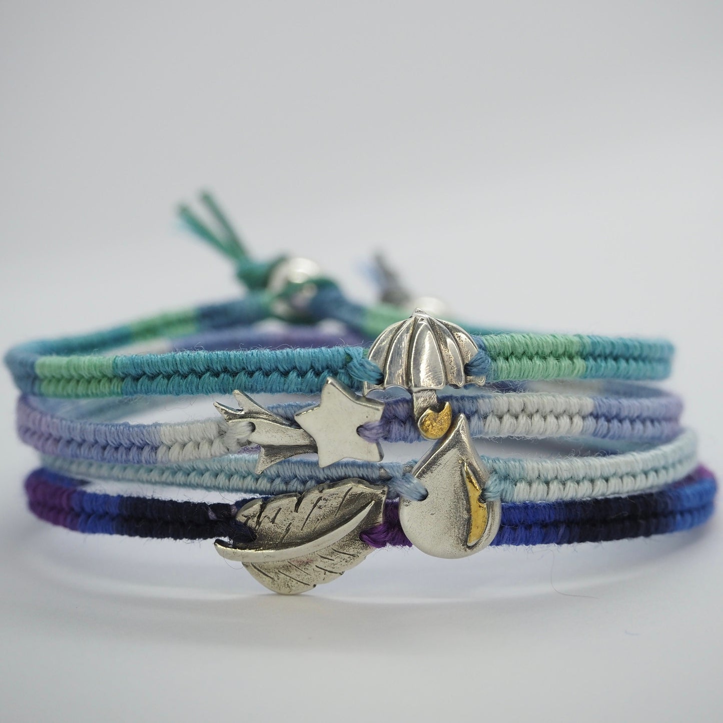 A gorgeous simple fine silver raindrop with gold highlights on a lovely blue leather, cotton and sterling silver friendship bracelet.