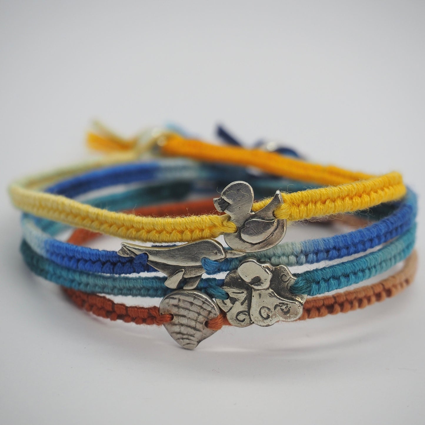 A cute tiny handmade fine silver octopus on a beautiful turquoise blue leather, sterling silver and cotton friendship bracelet.