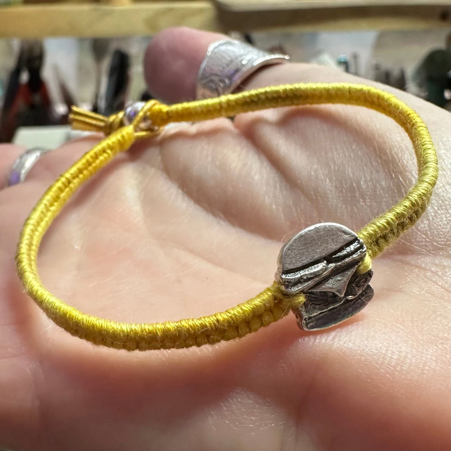 A unique tiny fine silver burger charm on a beautiful yellow leather, sterling silver and cotton friendship bracelet.