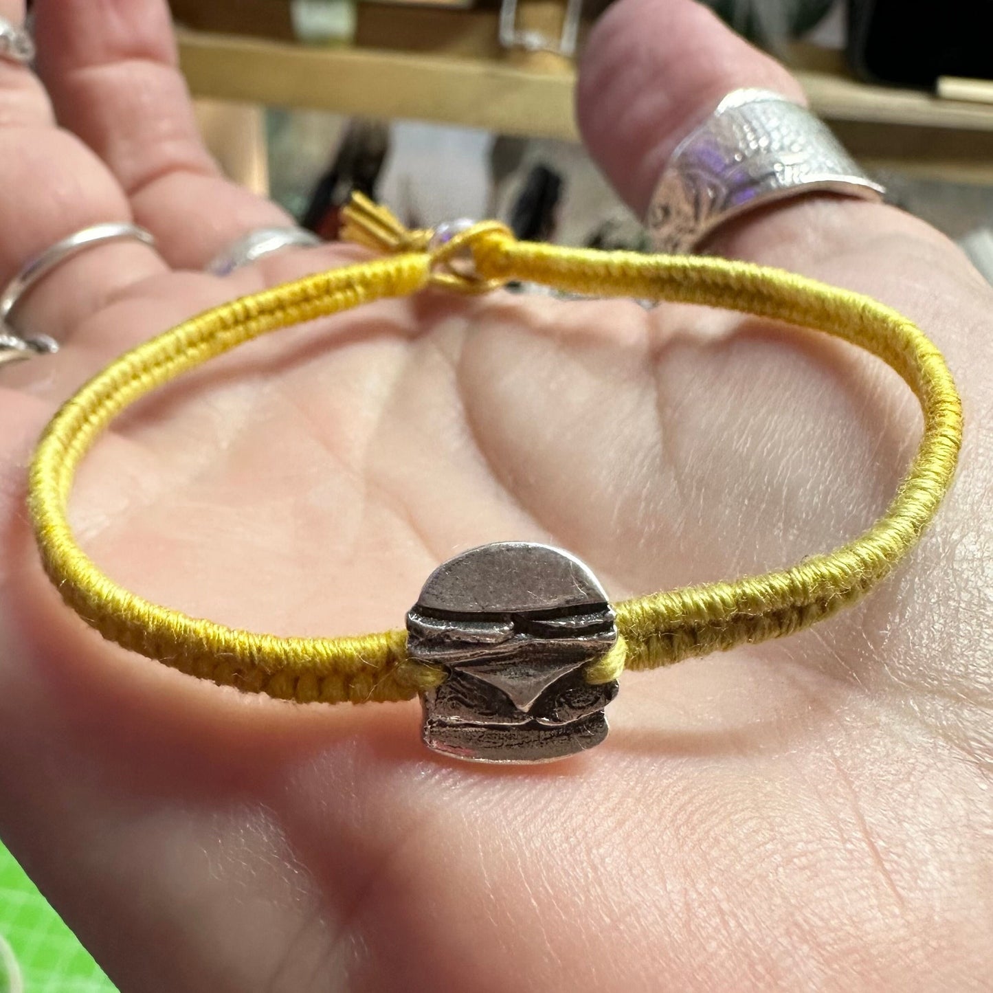 A unique tiny fine silver burger charm on a beautiful yellow leather, sterling silver and cotton friendship bracelet.