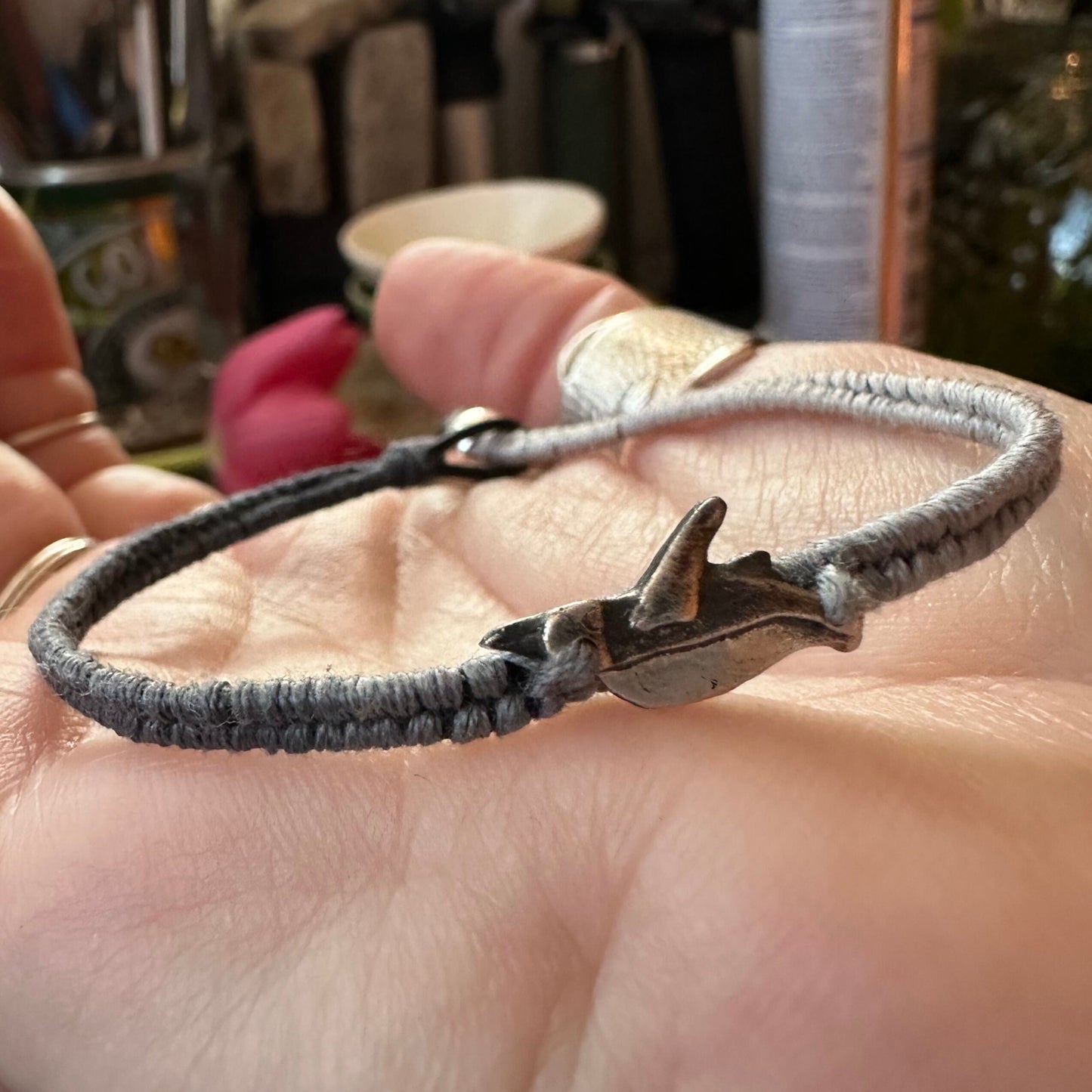 A lovely soft black and grey leather, cotton friendship and sterling silver bracelet with a handmade fine silver penguin.