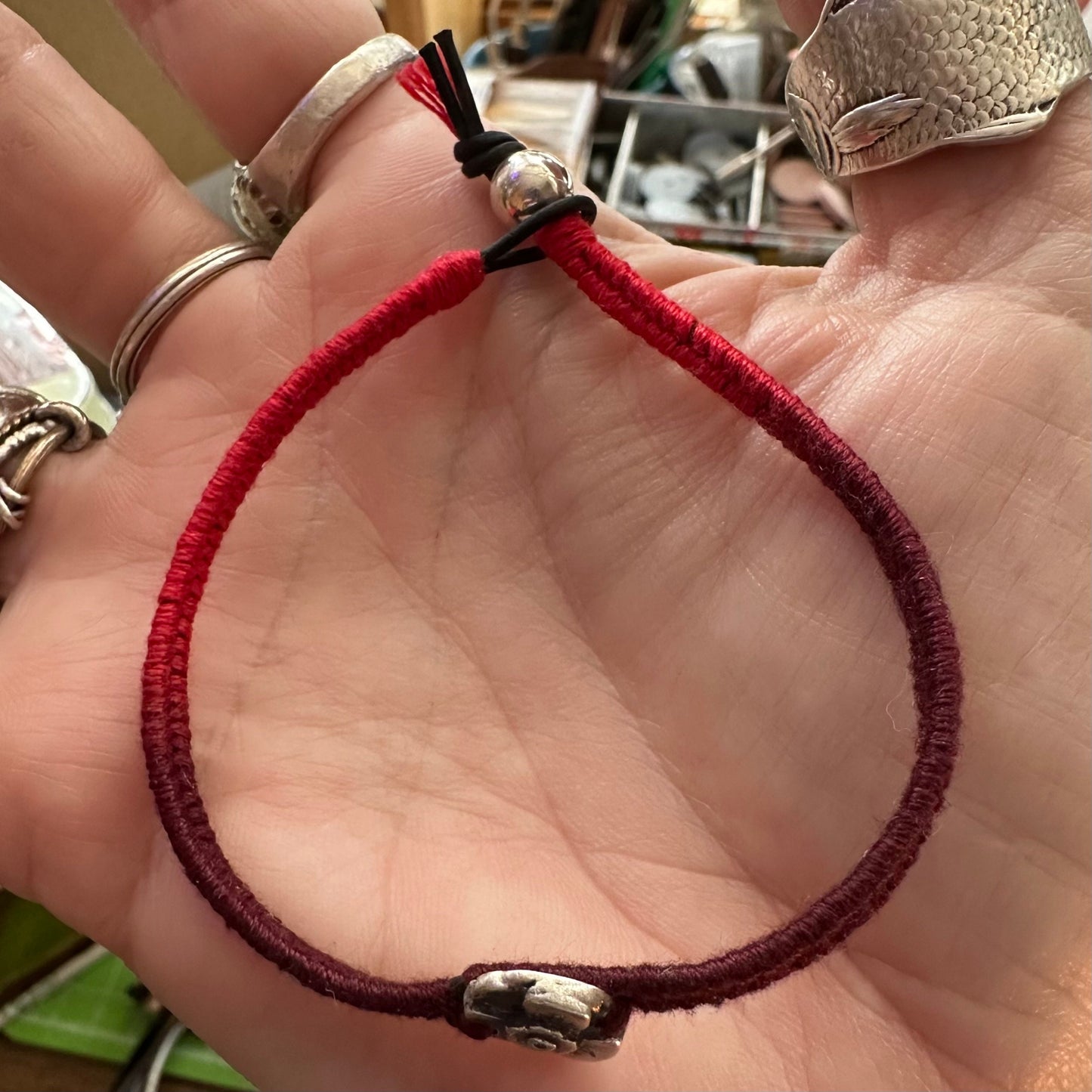 A beautiful handmade fine silver poppy on a gorgeous deep red leather, cotton and sterling silver friendship bracelet.
