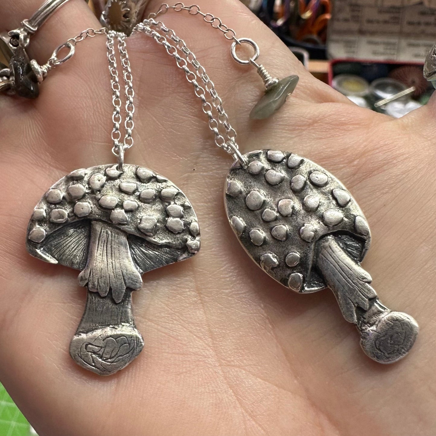 A beautiful handmade fine silver toadstool mushroom pendant hung on a sterling silver chain.