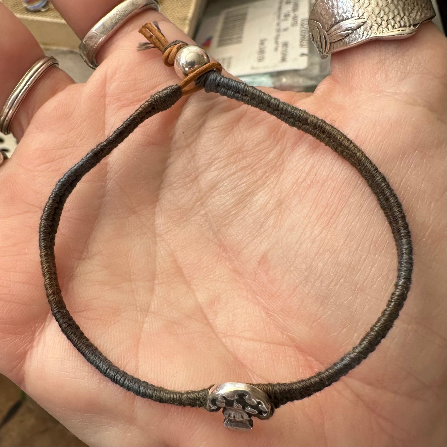 A beautiful handmade fine silver toadstool on earthy tones leather, sterling silver and cotton friendship bracelet.