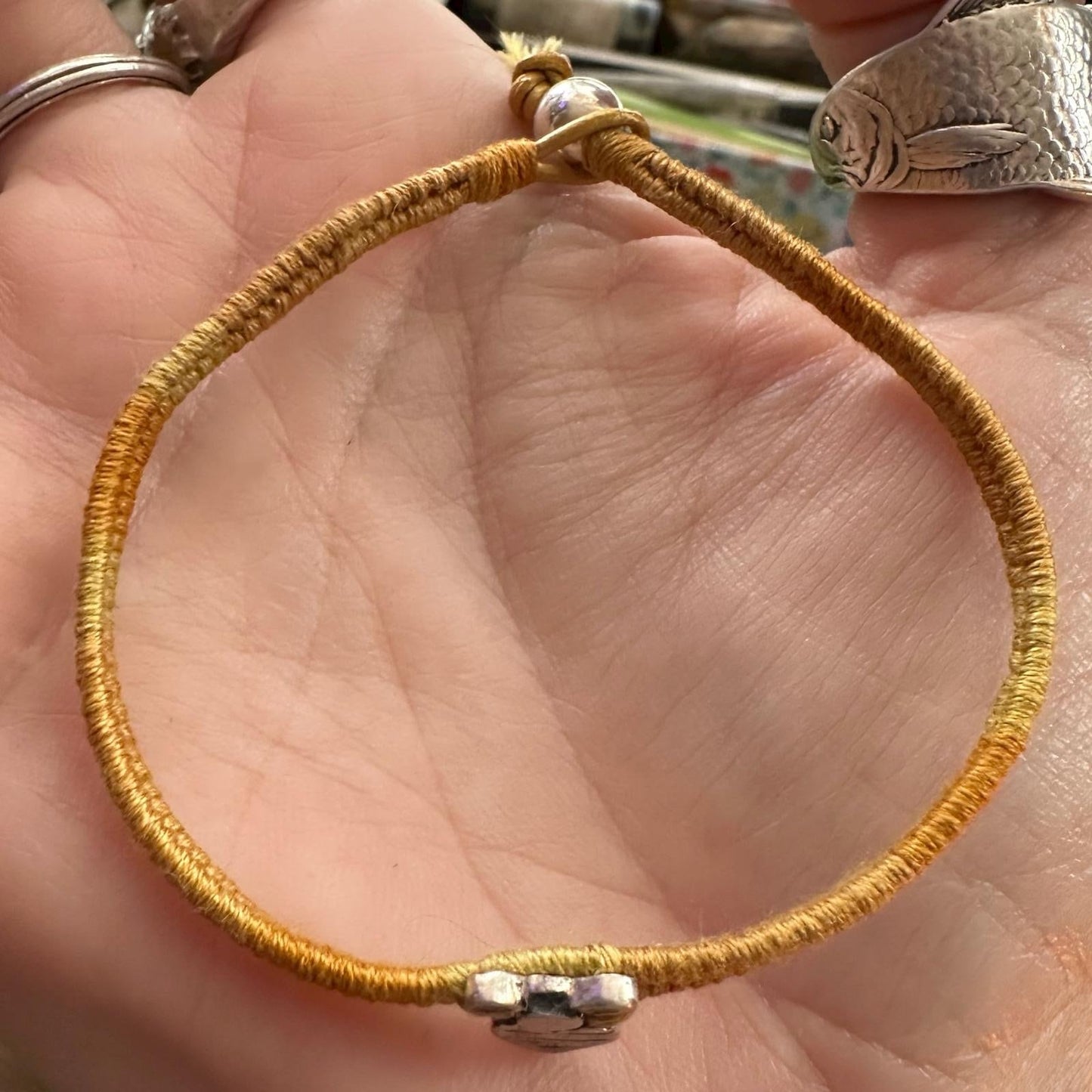 A gorgeous little bumble bee handmade in fine silver on a soft yellow leather, sterling silver and cotton friendship bracelet.