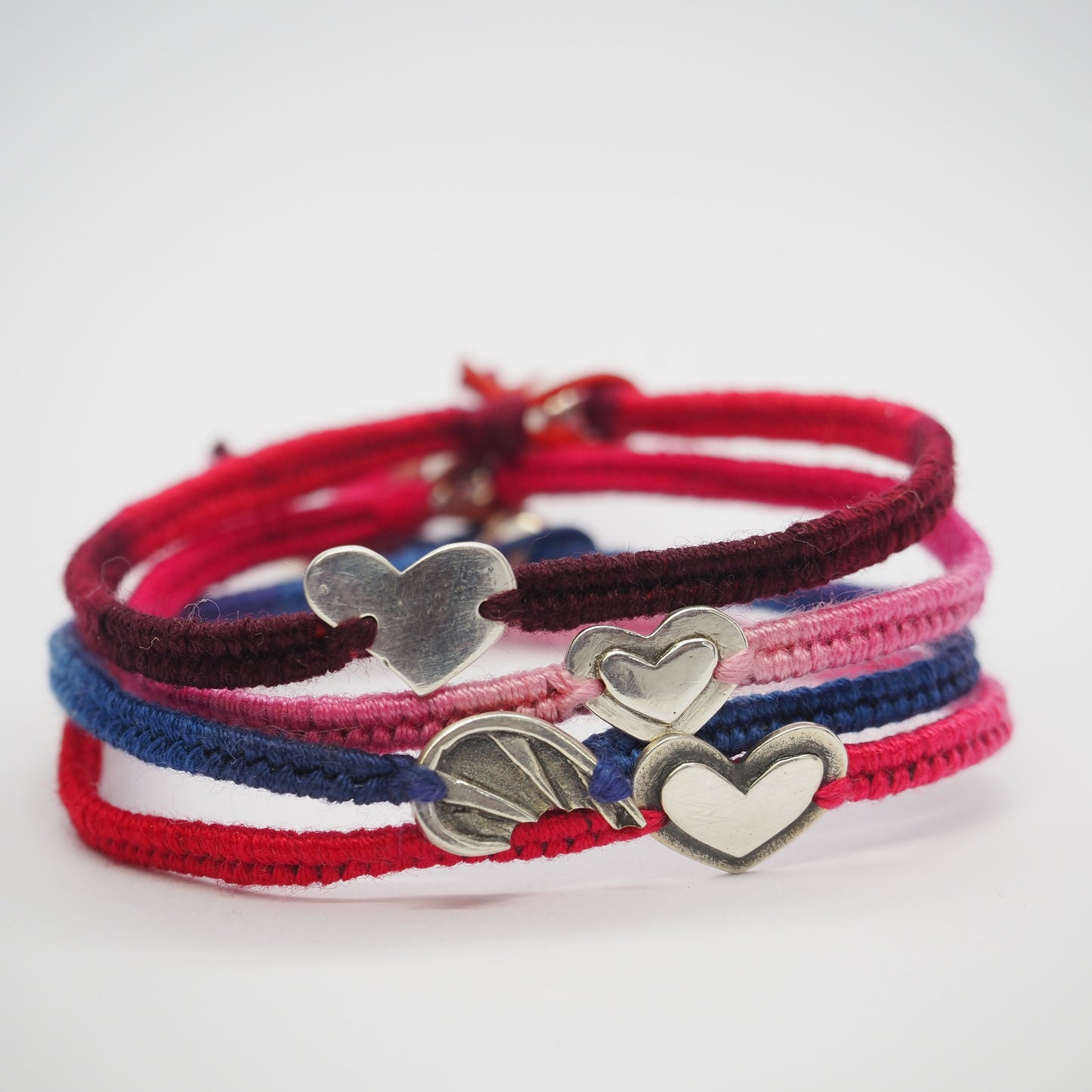A gorgeous faded pink friendship bracelet with a handmade fine silver layered heart on cotton and leather with a sterling silver bead