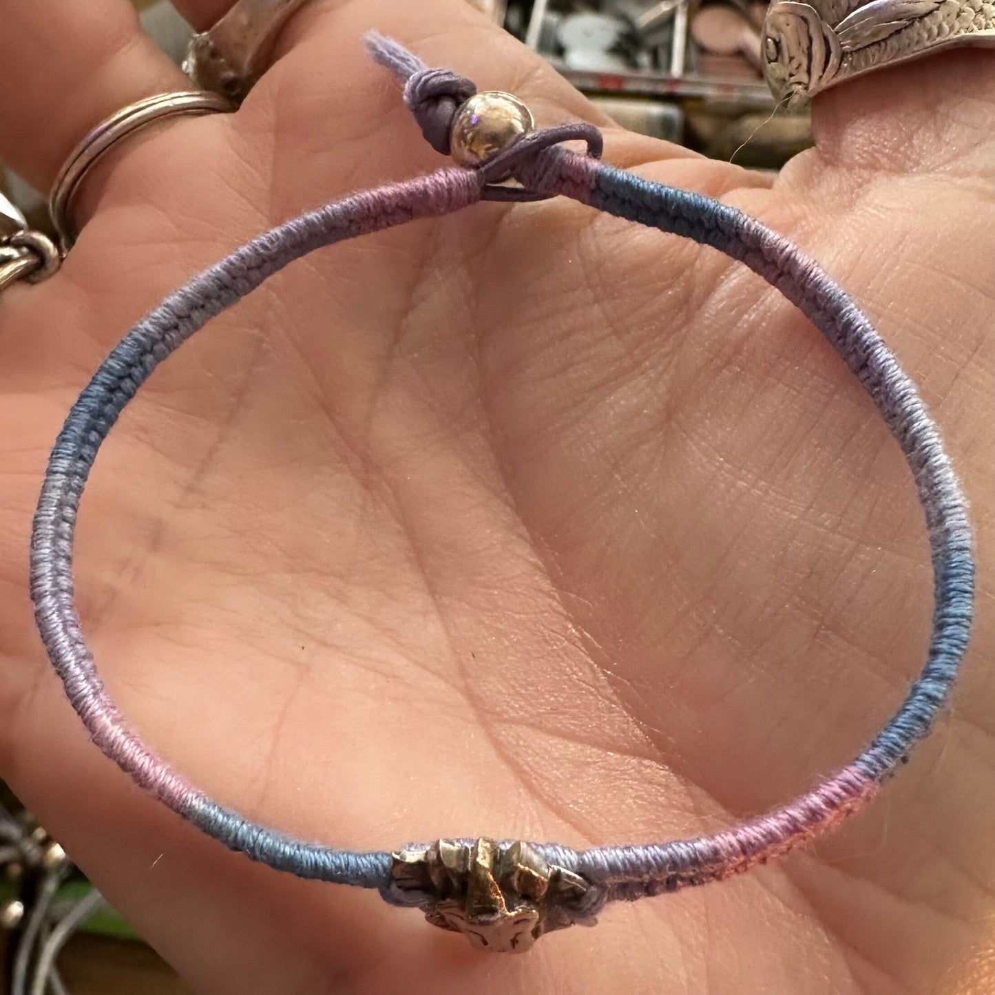 A beautiful little fine silver unicorn on a beautiful pinky purple leather, cotton and sterling silver woven charm bracelet.