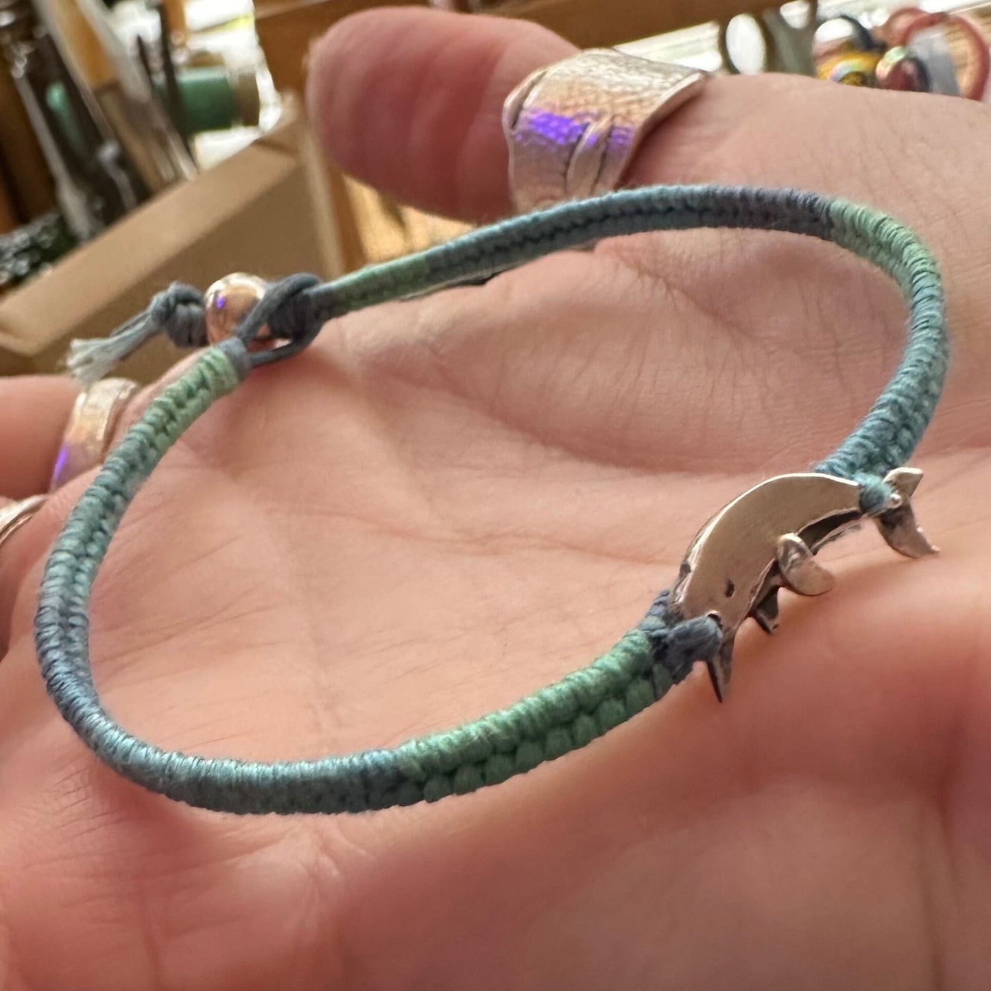 A gorgeous narwhal hand made in fine silver on a beautiful graduated blue cotton, leather and sterling silver friendship bracelet.