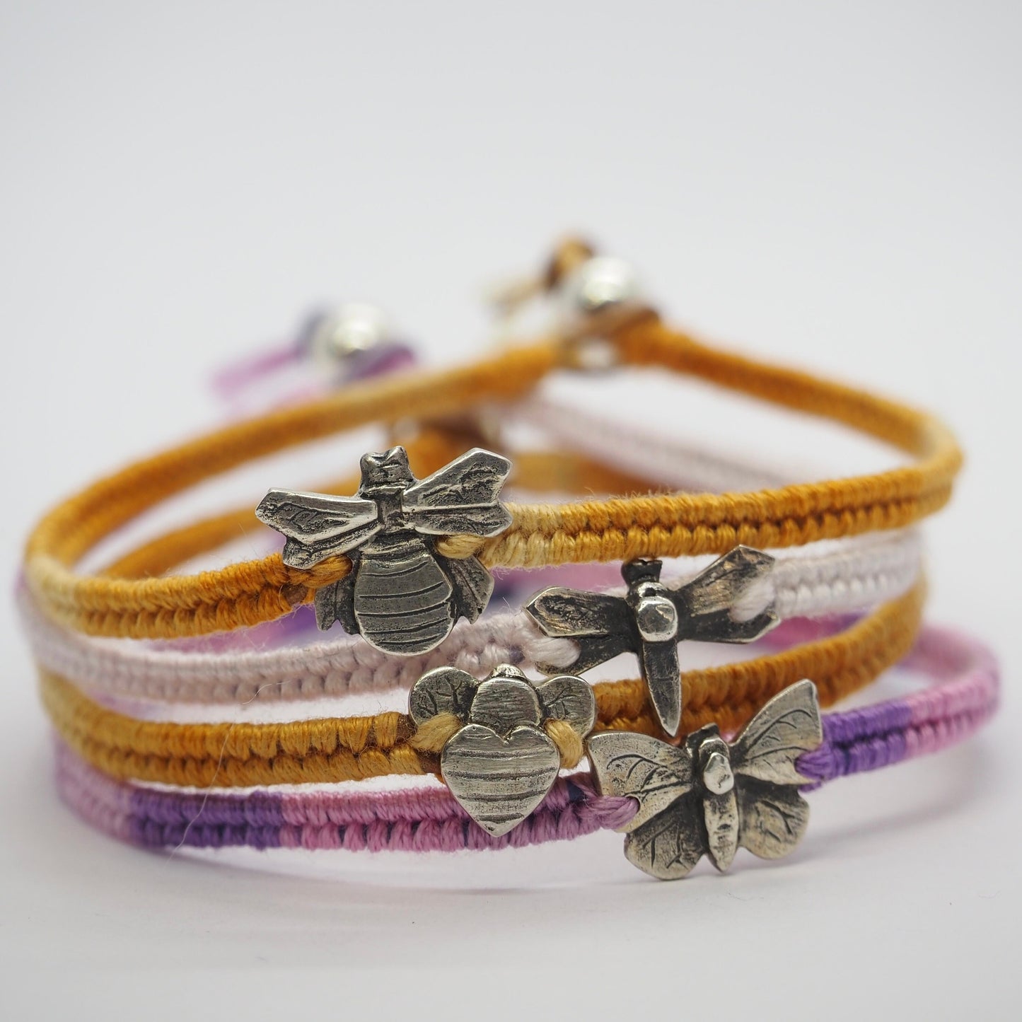 A simple summery yellow leather, cotton and sterling silver woven charm bracelet with a tiny unique handmade fine silver bumble bee.