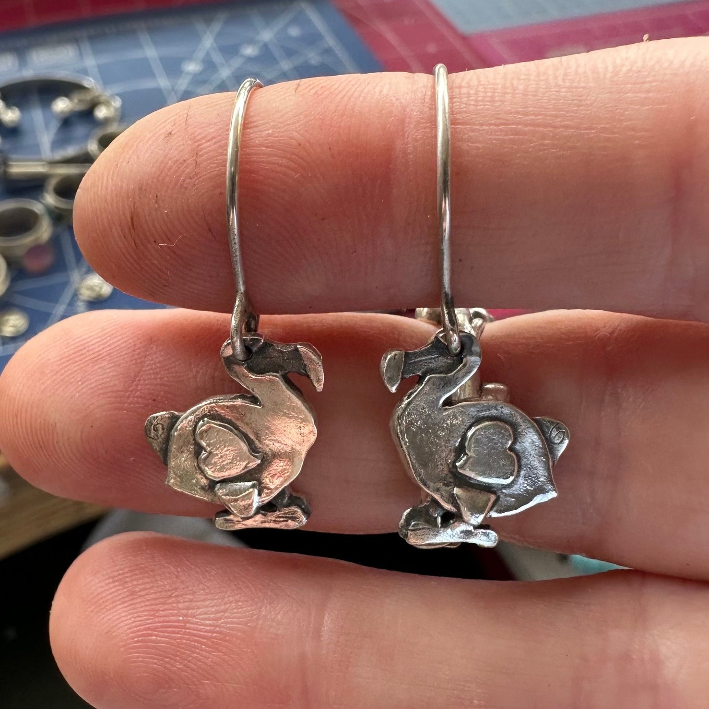 A gorgeous pair of handmade fine silver dodo earrings hung on sterling silver wires.