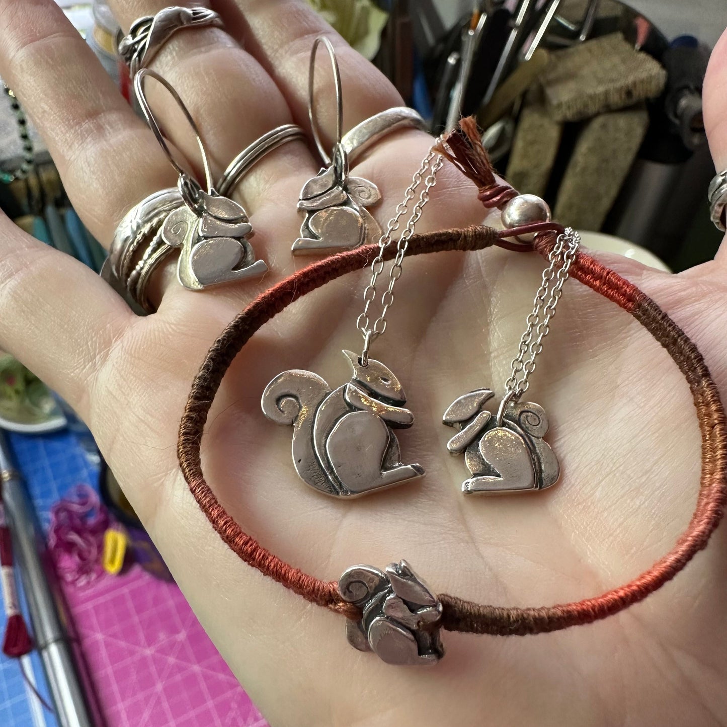 A beautiful solid fine silver squirrel pendant on a sterling silver chain with a gem attached to the end.