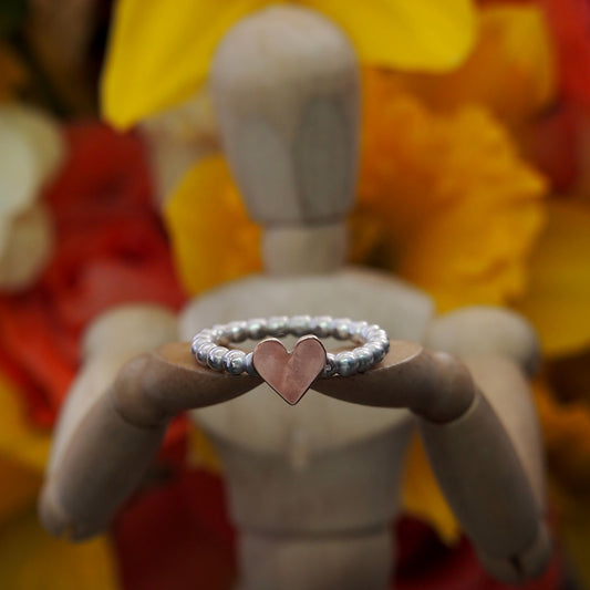 A cute dainty sterling silver and handcut 9ct rose gold heart stacking midi ring on a band of little silver spheres.