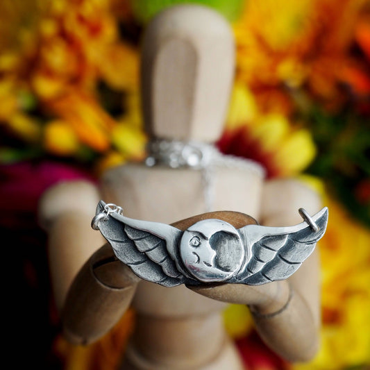 A beautiful tattoo inspired winged moon necklace hand made fine silver on a sterling silver chain.