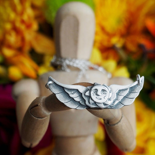 A glorious tattoo inspired winged sun necklace hand made fine silver on a sterling silver chain.