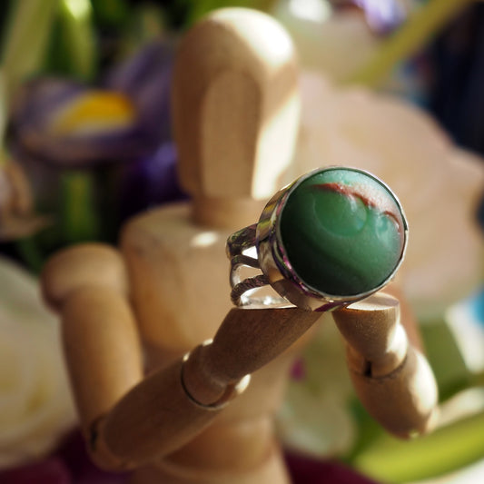 A totally unique sterling silver ring with green and red sea glass marble set on hand constructed band.