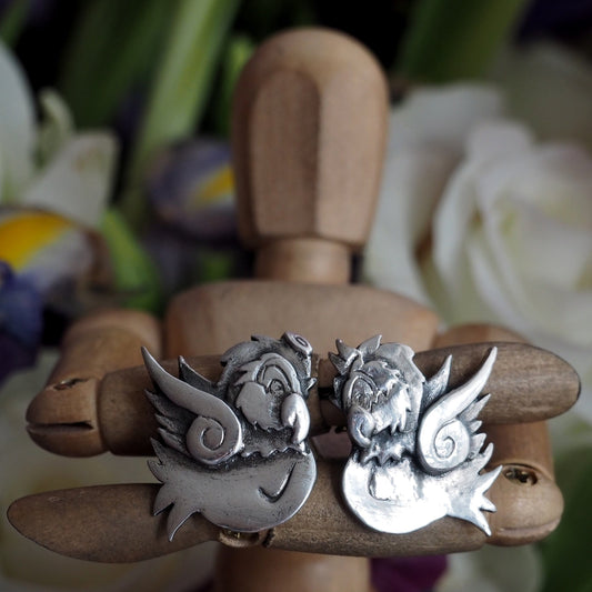 A beautiful tattoo style pair of 'angel' and 'devil' fine silver cufflinks, secured with sterling silver chain.