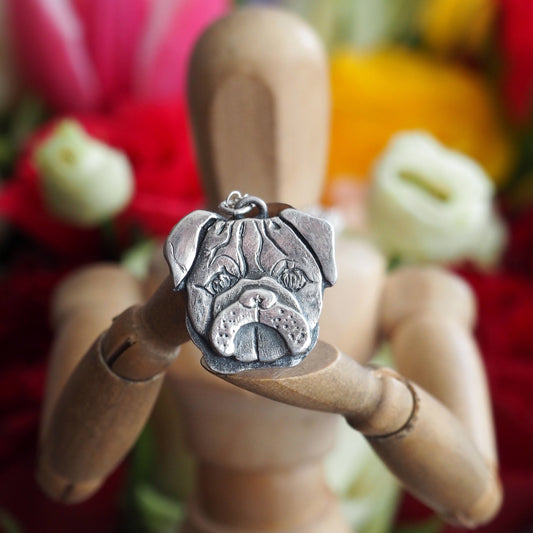 A delightful hand made fine silver pug dog pendant on a sterling silver chain.