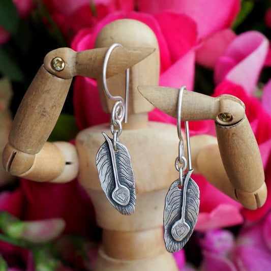 A pair of beautifully simple handmade unique fine silver peacock feather earrings on hand made sterling silver wires.