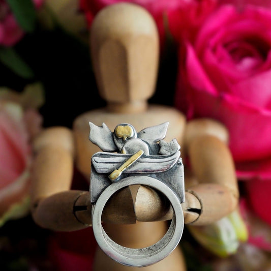 A stack of rings hand made in fine silver with touches of gold telling the classic tale of the owl and the pussy cat sailing in their boat