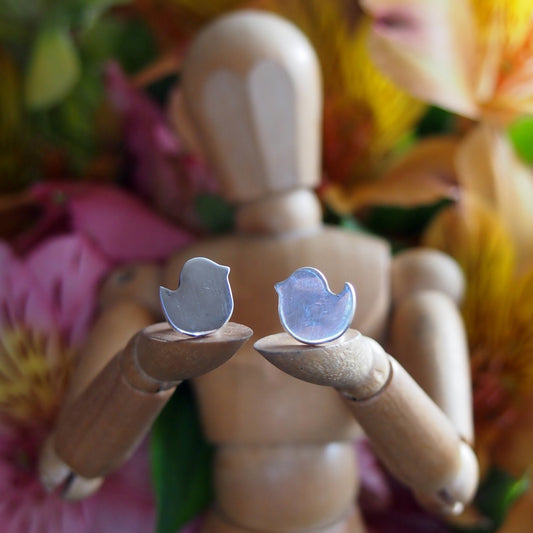 A beautifully simple pair of tiny bird stud earrings handmade in fine silver