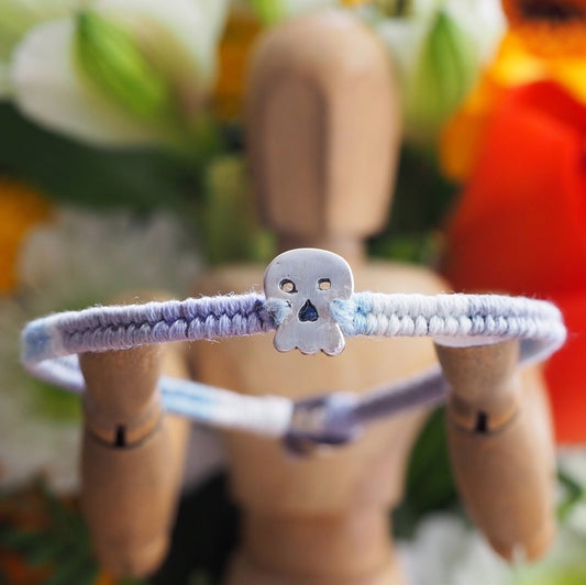 A wonderfully gothic tiny unique fine silver skull on a blues, lilac and greys leather, sterling silver and cotton friendship bracelet.